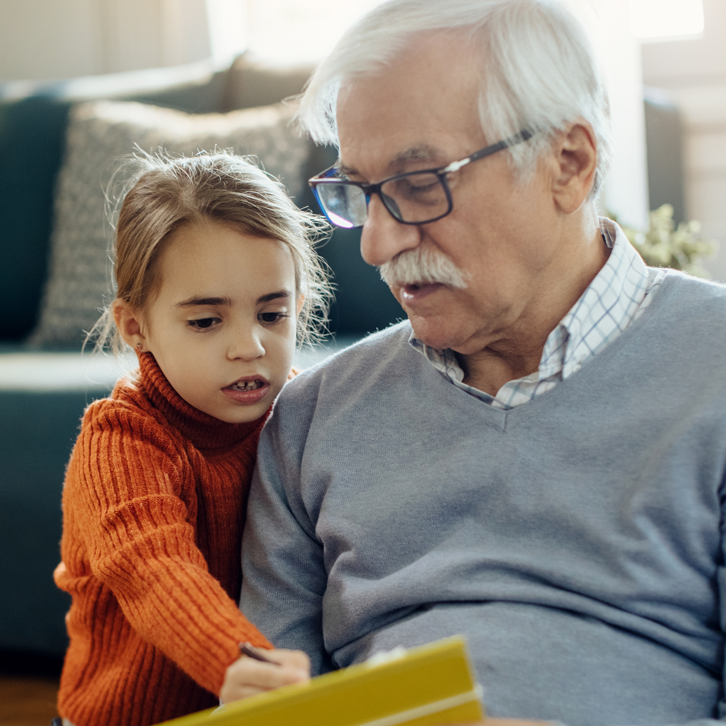 Grandfather reading with granddaughter